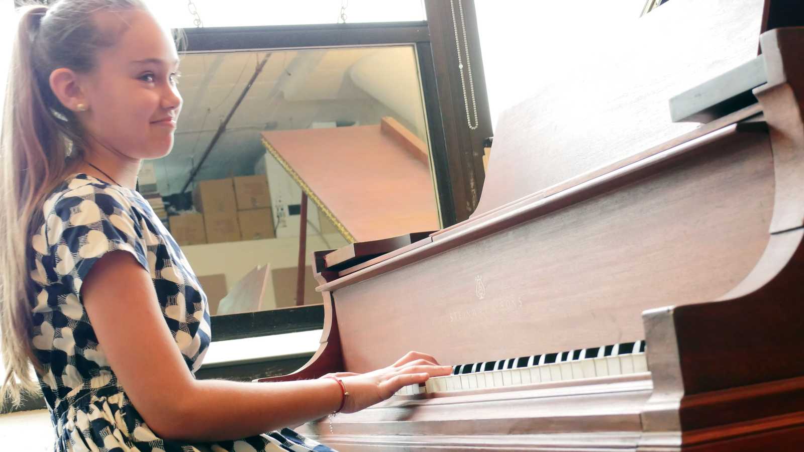 Young girl playing piano on a recital at Sage Music