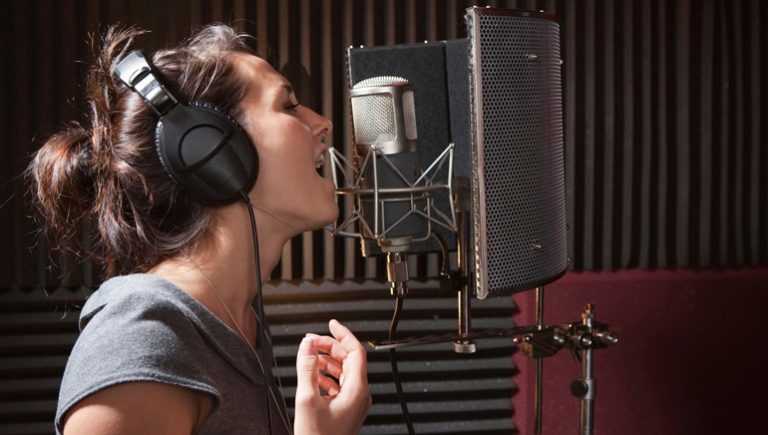 A young girl singing in a studio