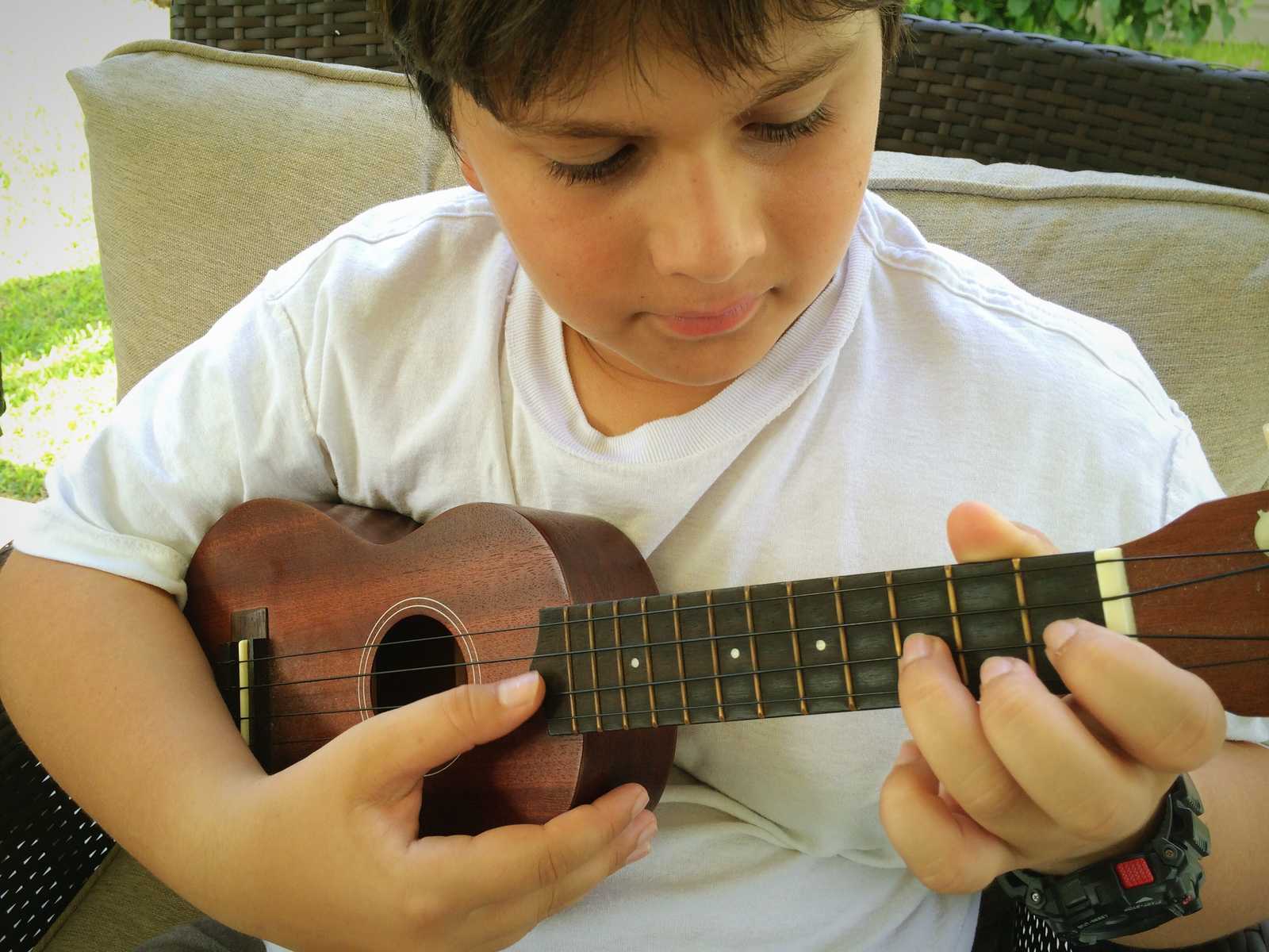 A boy playing the ukulele