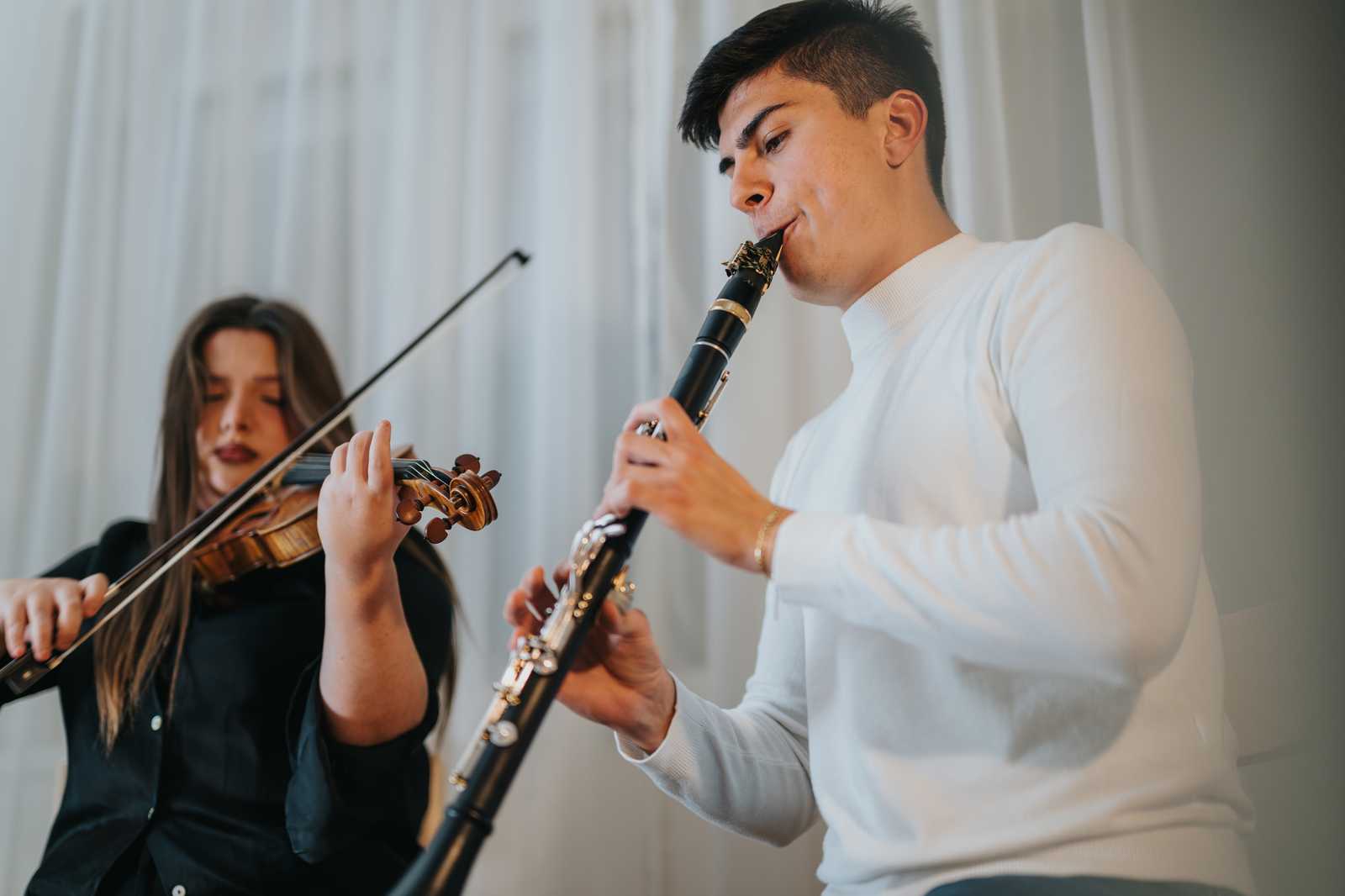 a man playing clarinet with a woman playing violin