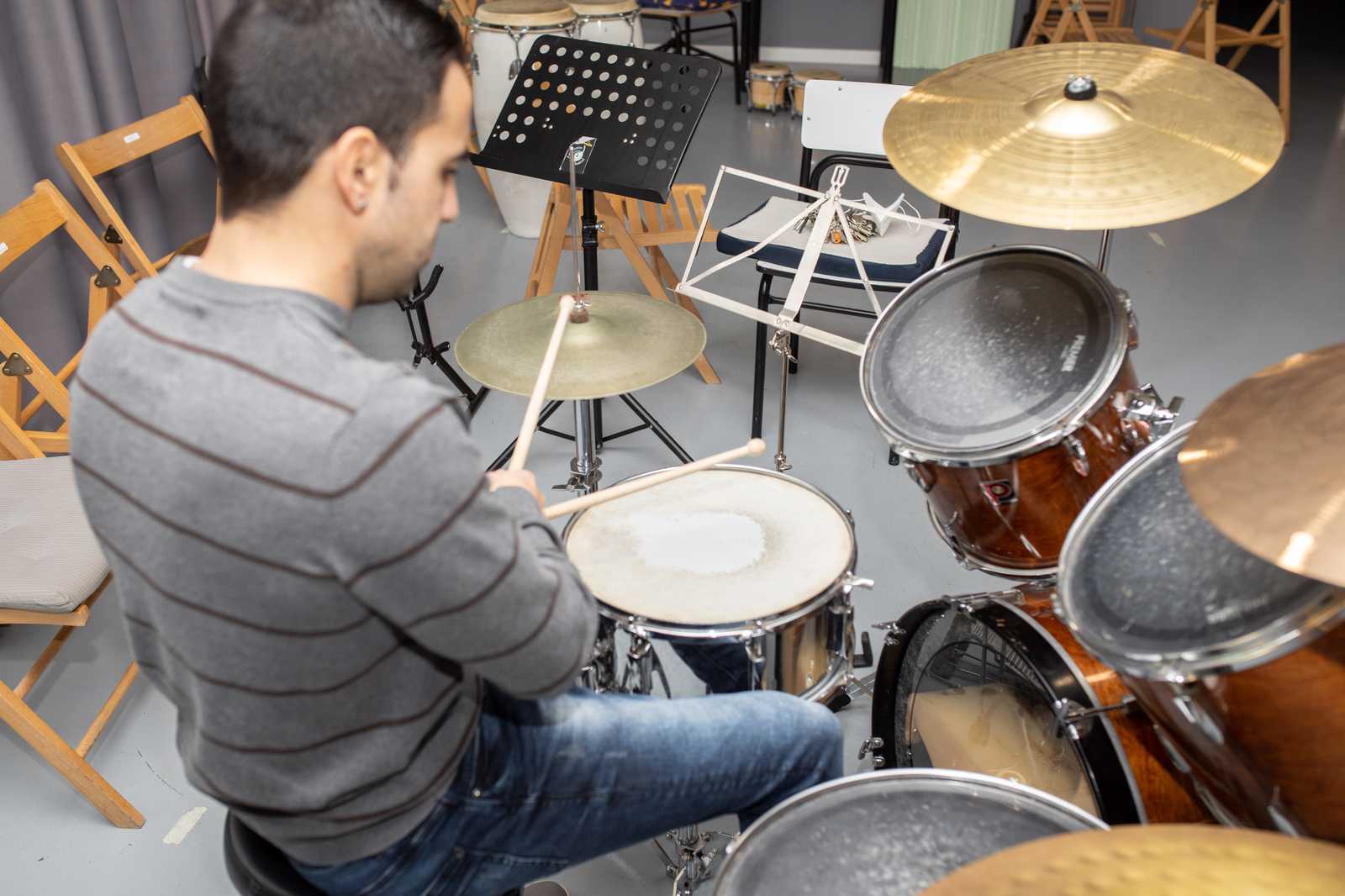 a man playing drum set in a music studio