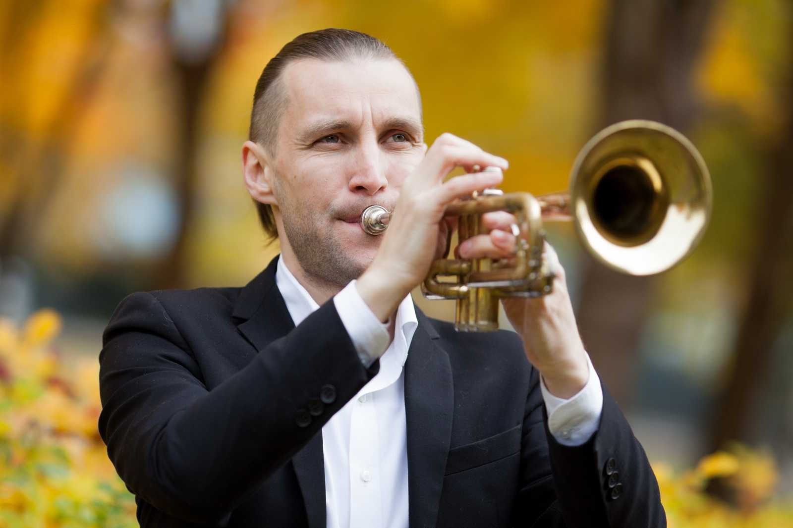 A man playing the trumpet wearing a suit