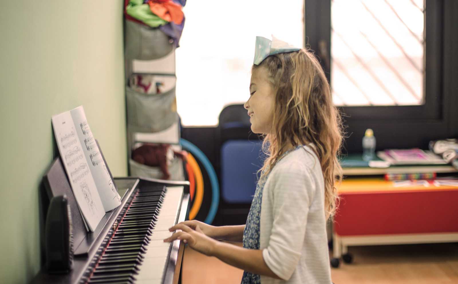 a teenage girl smiling and practicing piano