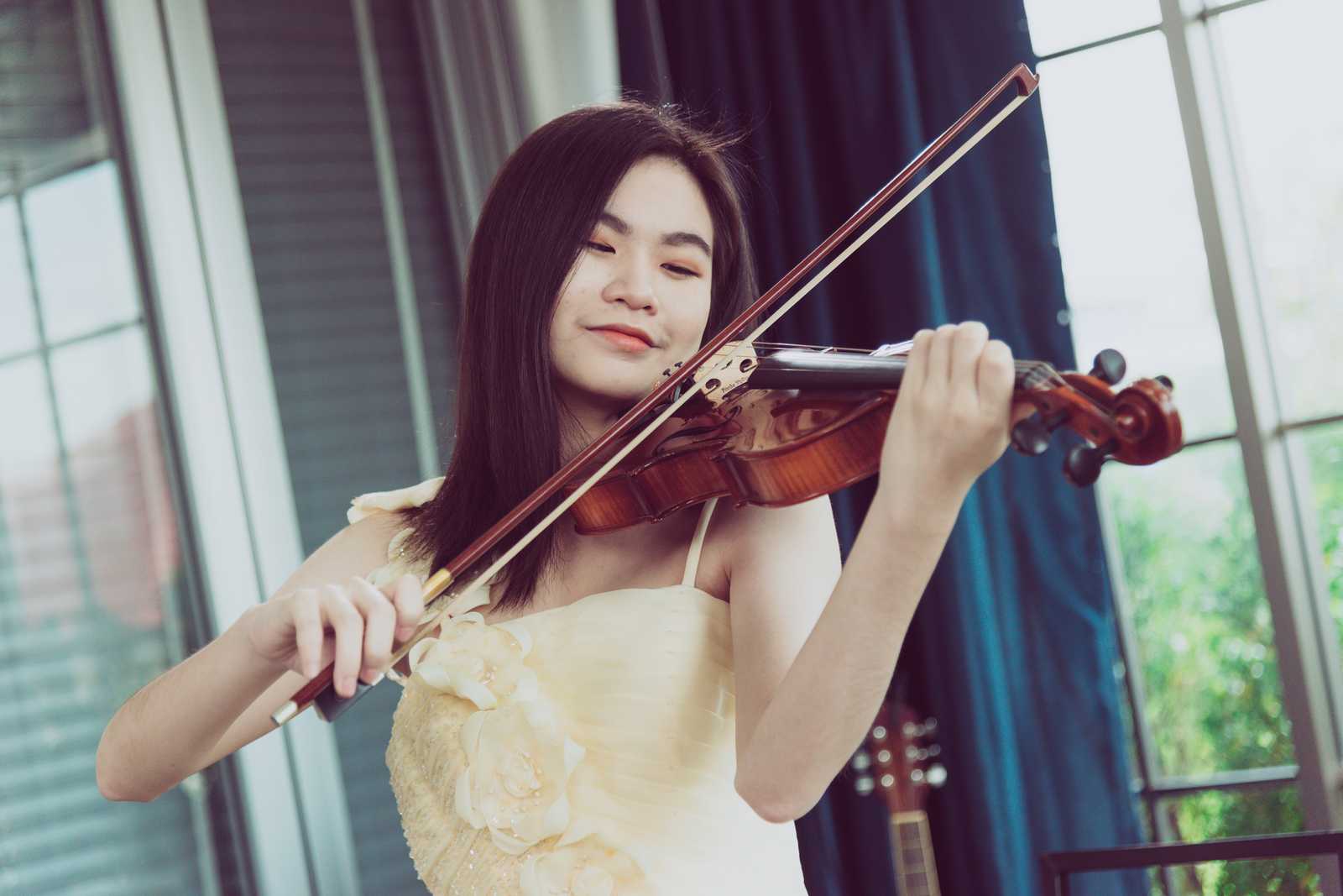 a woman practicing violin at home