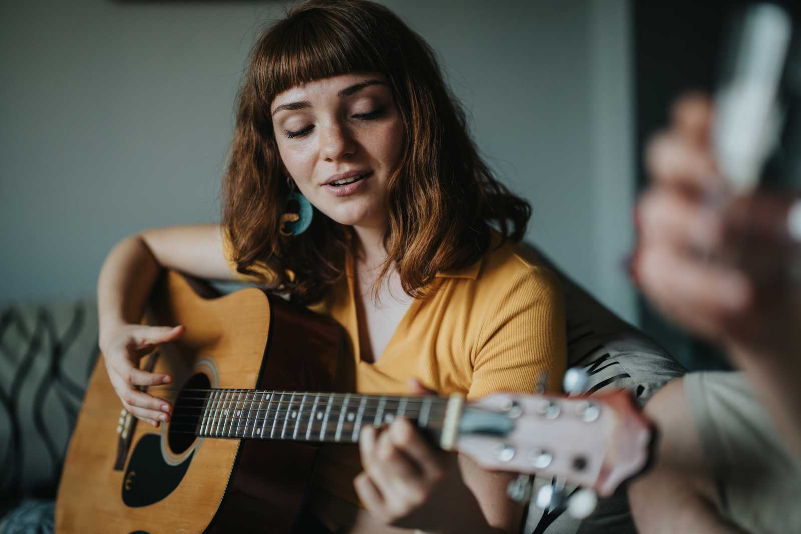 A woman strumming the guitar