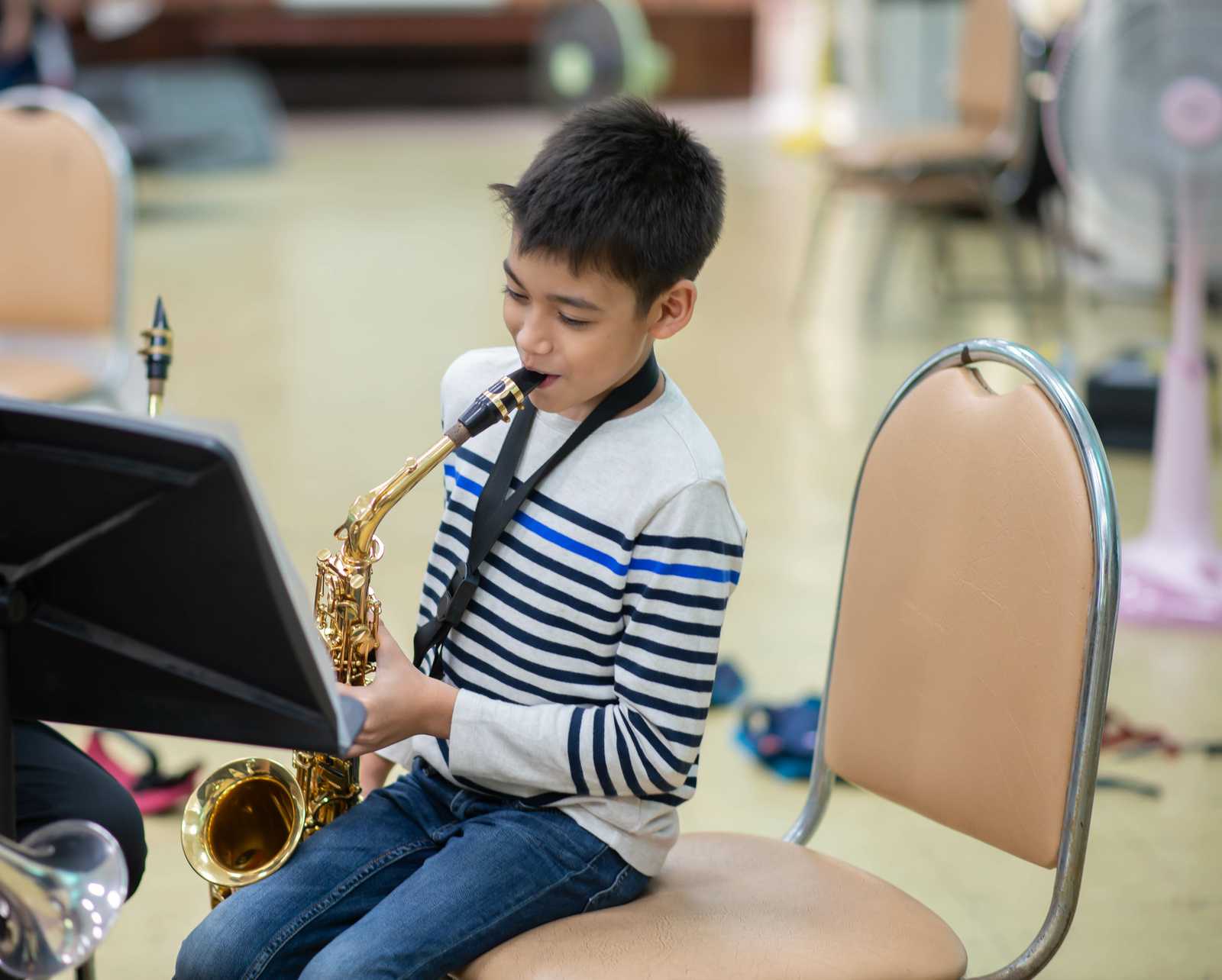 A young boy playing the saxophone