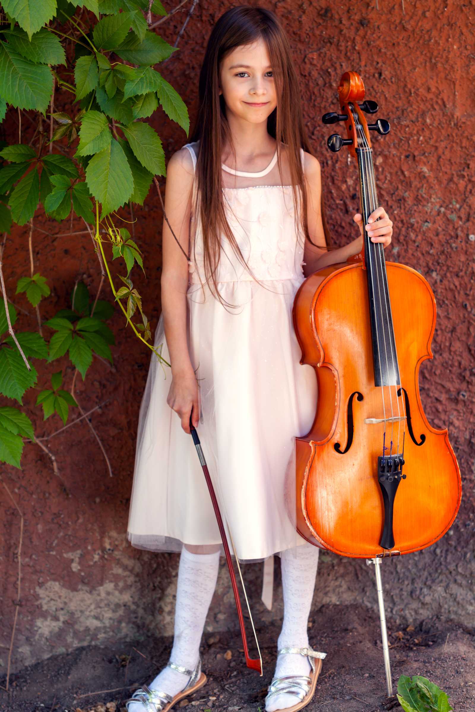 a young girl holding a cello