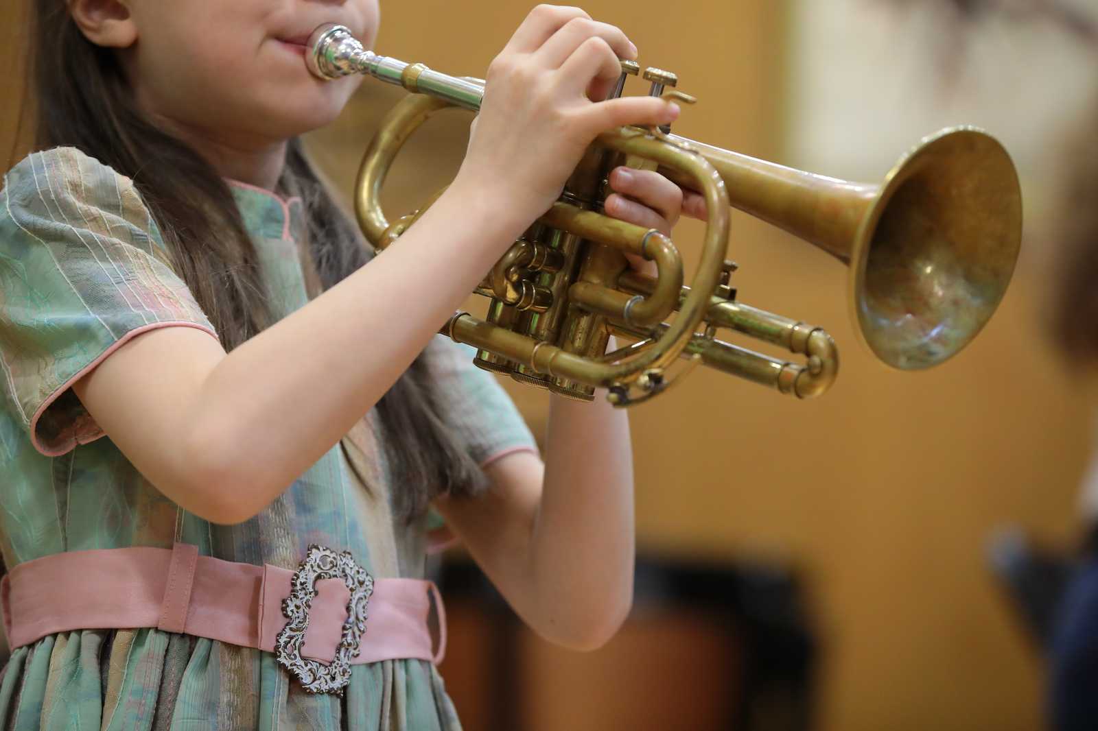 A young girl playing the trumpet