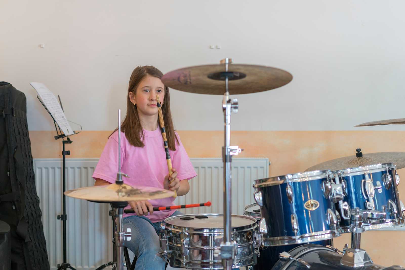 a young girl practicing on the drum set