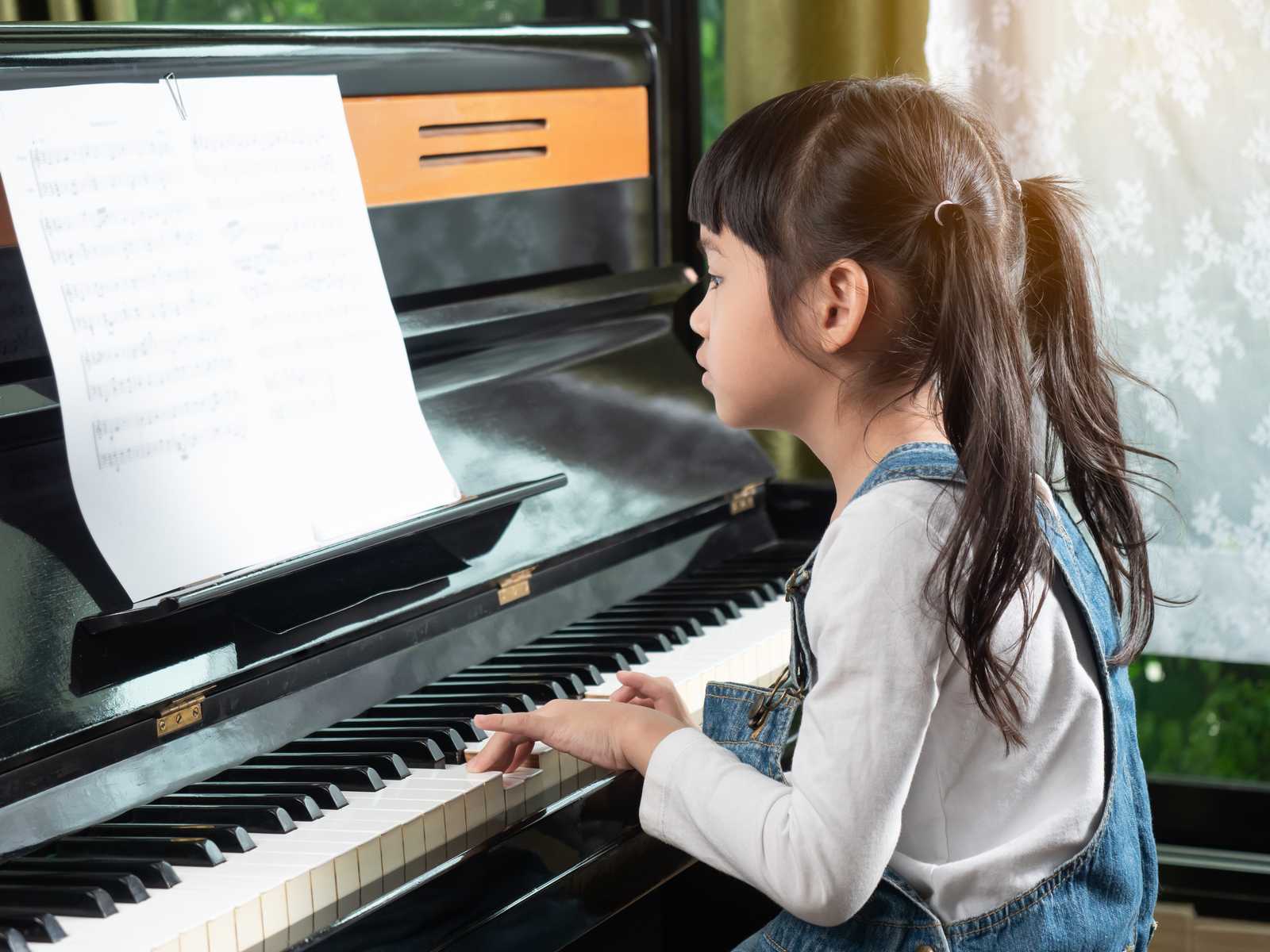 A young girl practicing piano