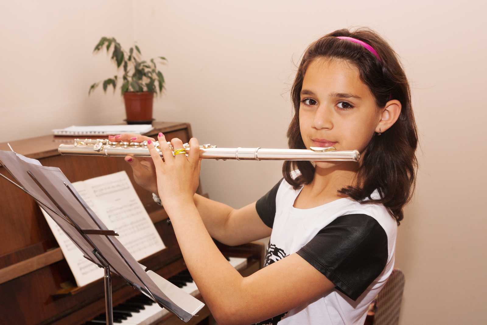 a young girl practicing the flute in a practice room