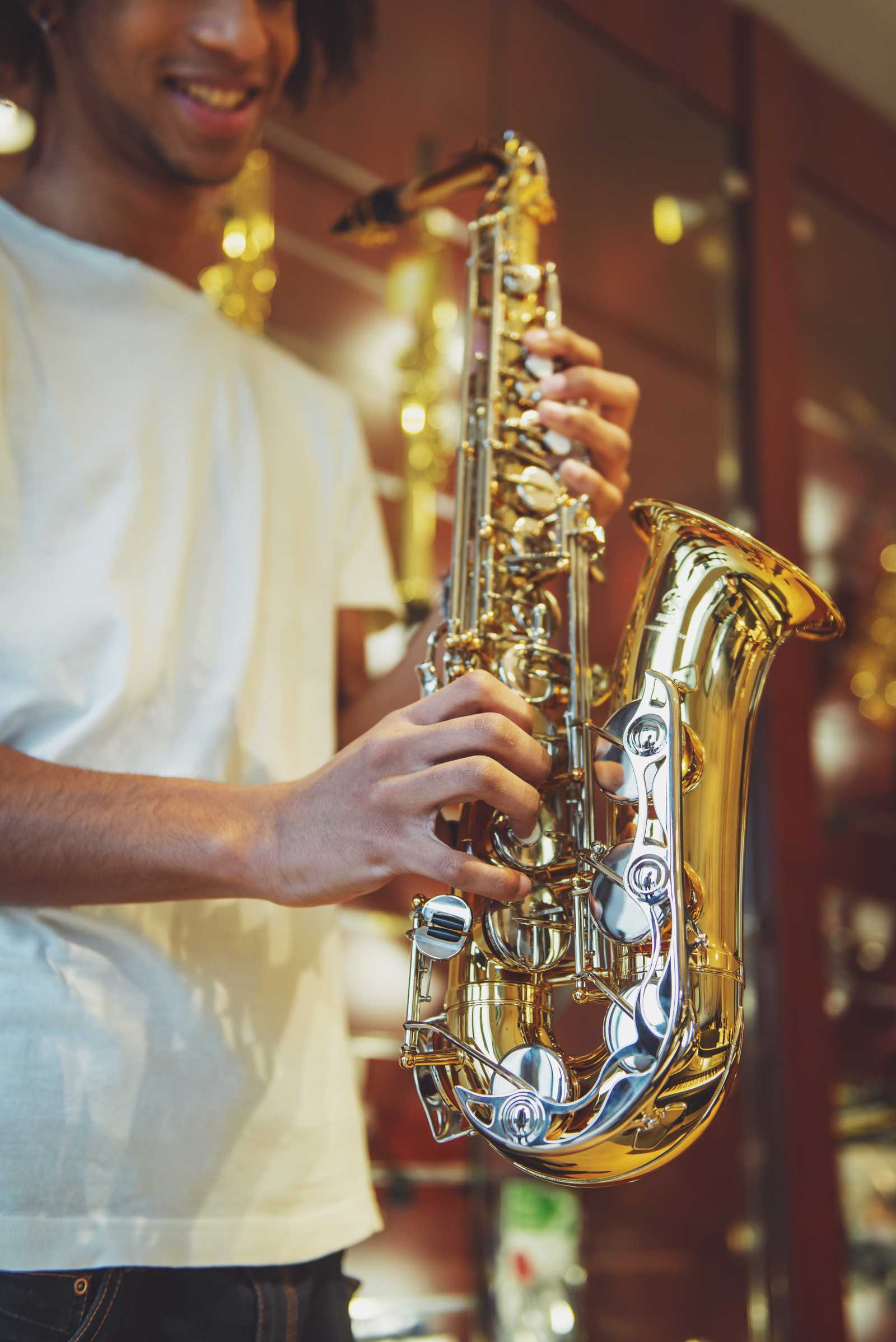 a young man holding his saxophone
