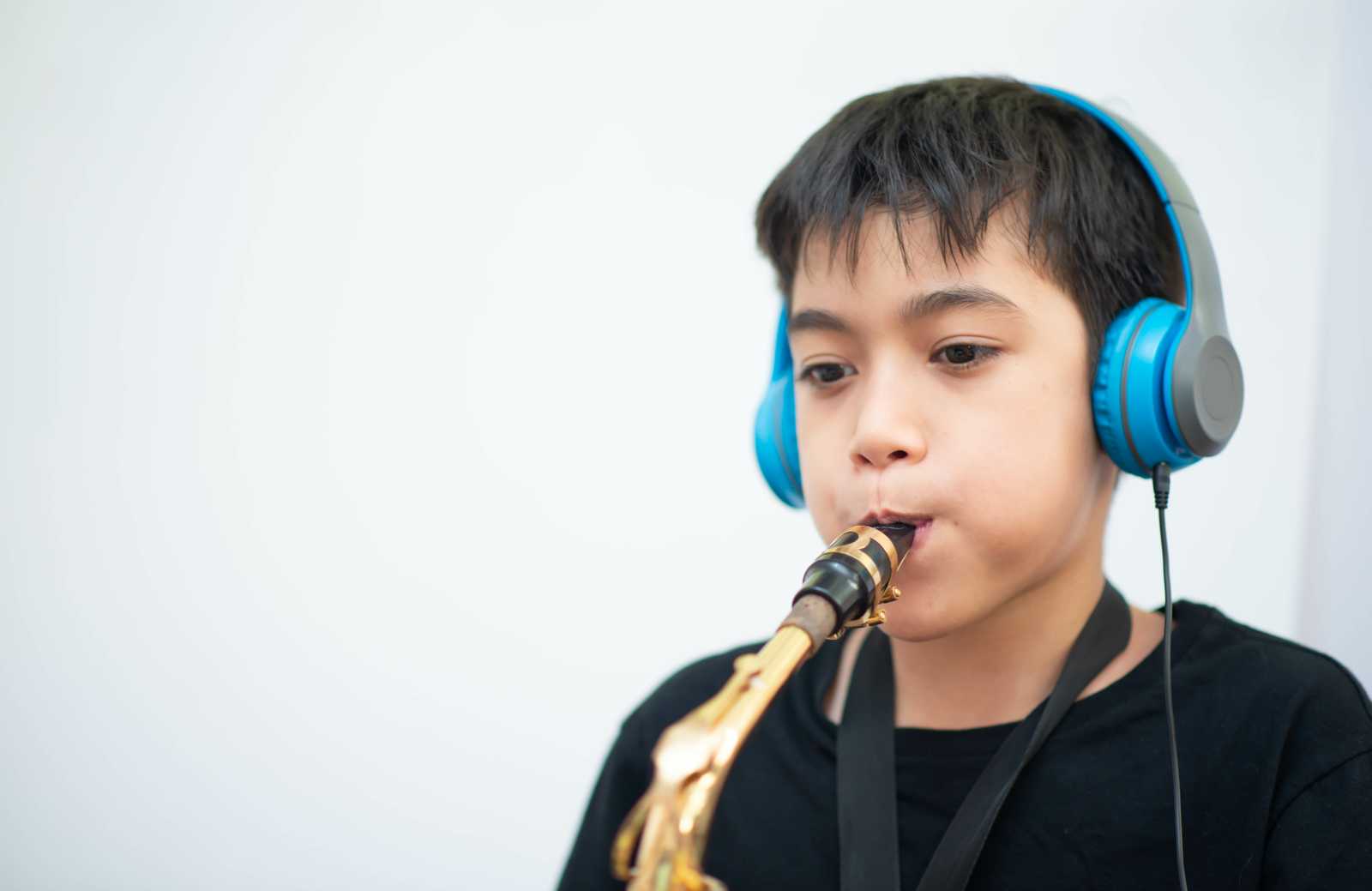 a boy wearing headphones playing saxophone