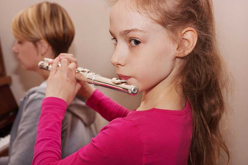 A young girl playing the flute
