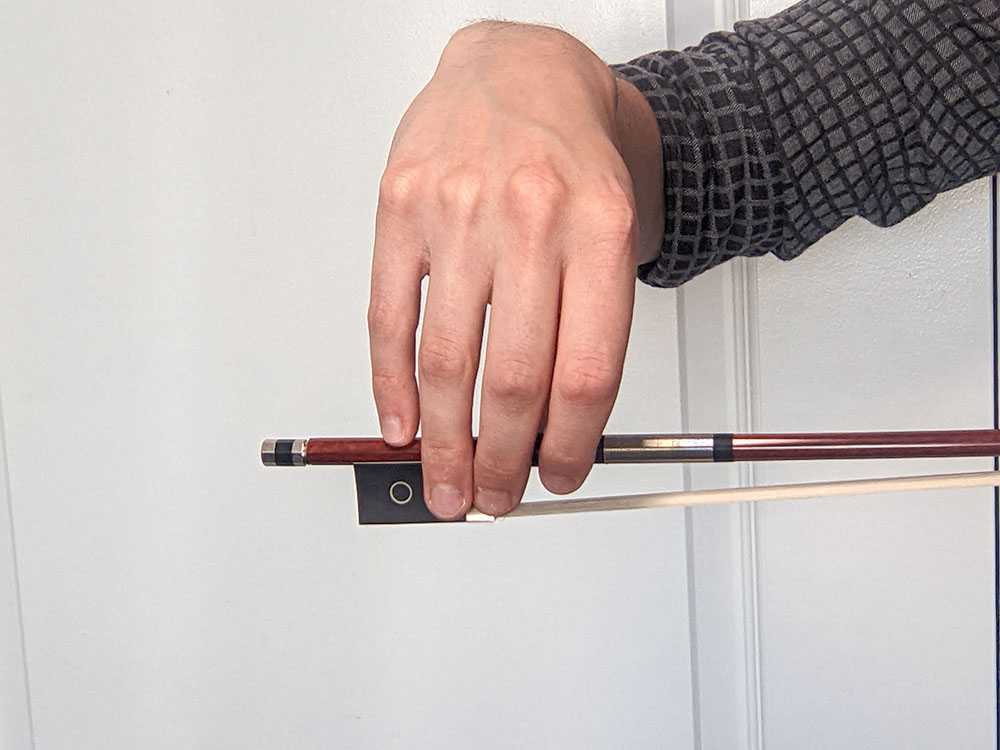 The hand is too high on this violin bow hold. The wrist is also too far flexed.