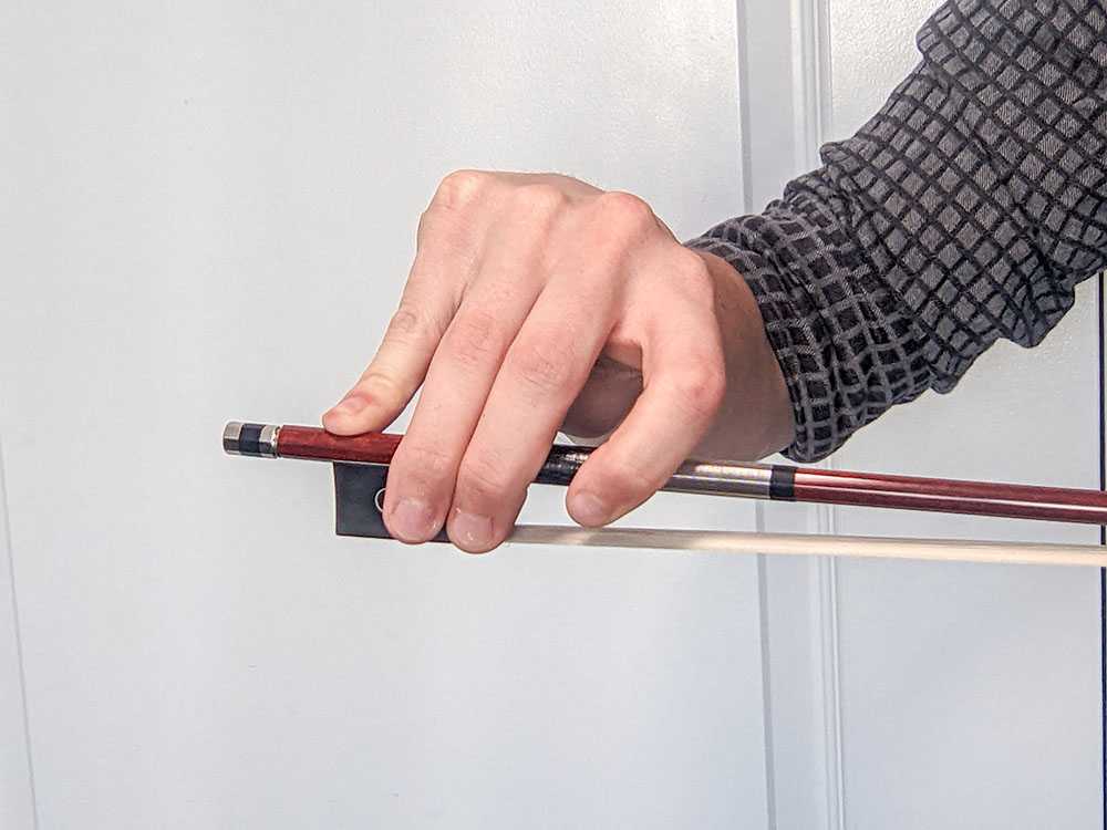 The pinky finger is locked and not curved, or slightly flexed as it should be.