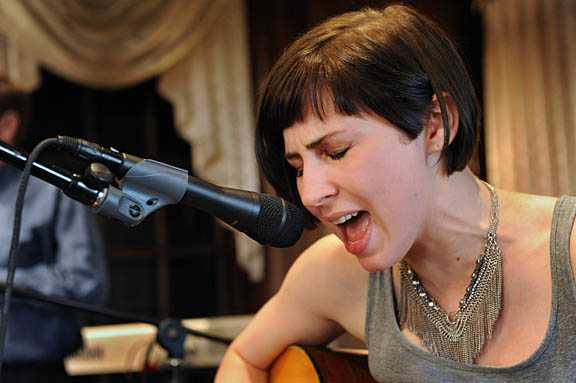A woman singing with her guitar