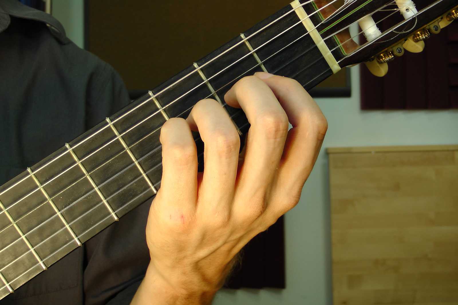 Midrange positioning of the left hand fingers on the guitar