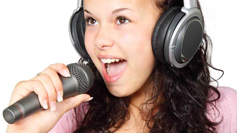 A young girl singing with a microphone