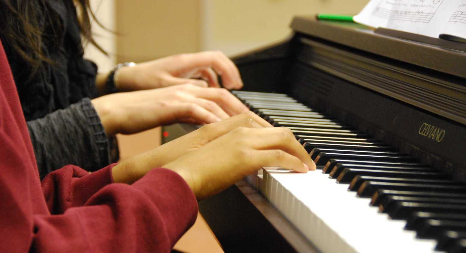 Teacher accompanying student on piano