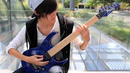 Tim henson holding the guitar