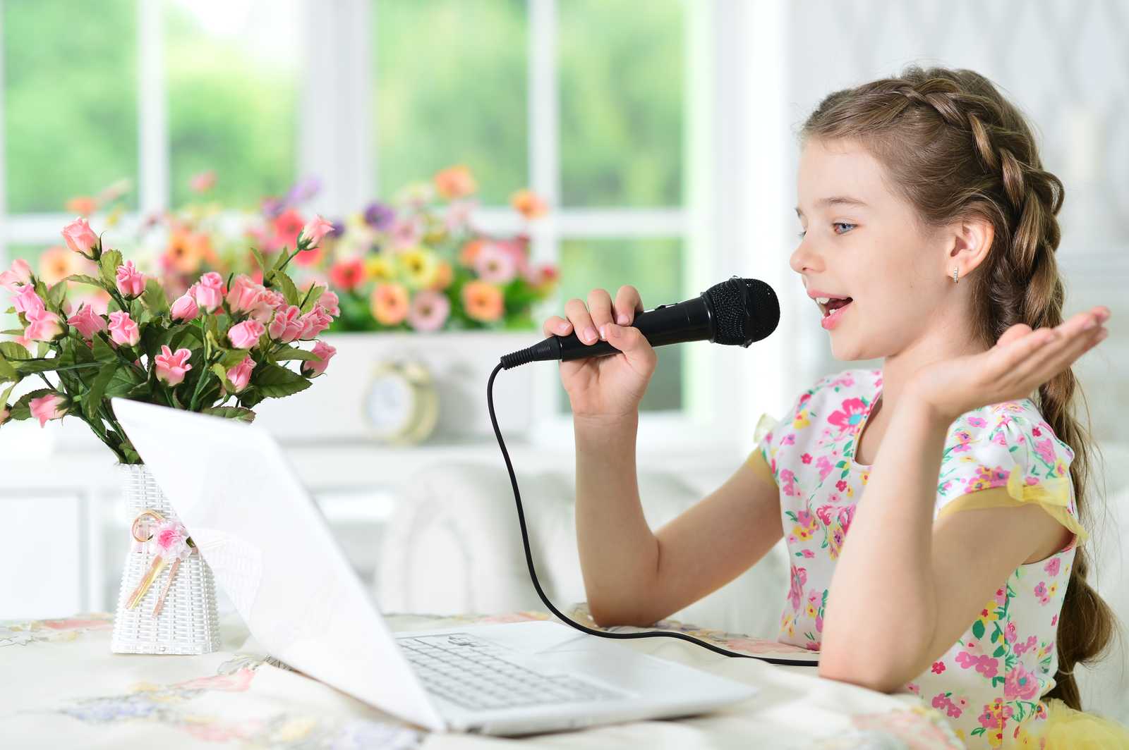 a young girl singing with microphone online
